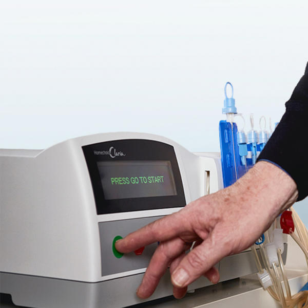 Close up of a patient pressing a start button on the Homechoice Claria system